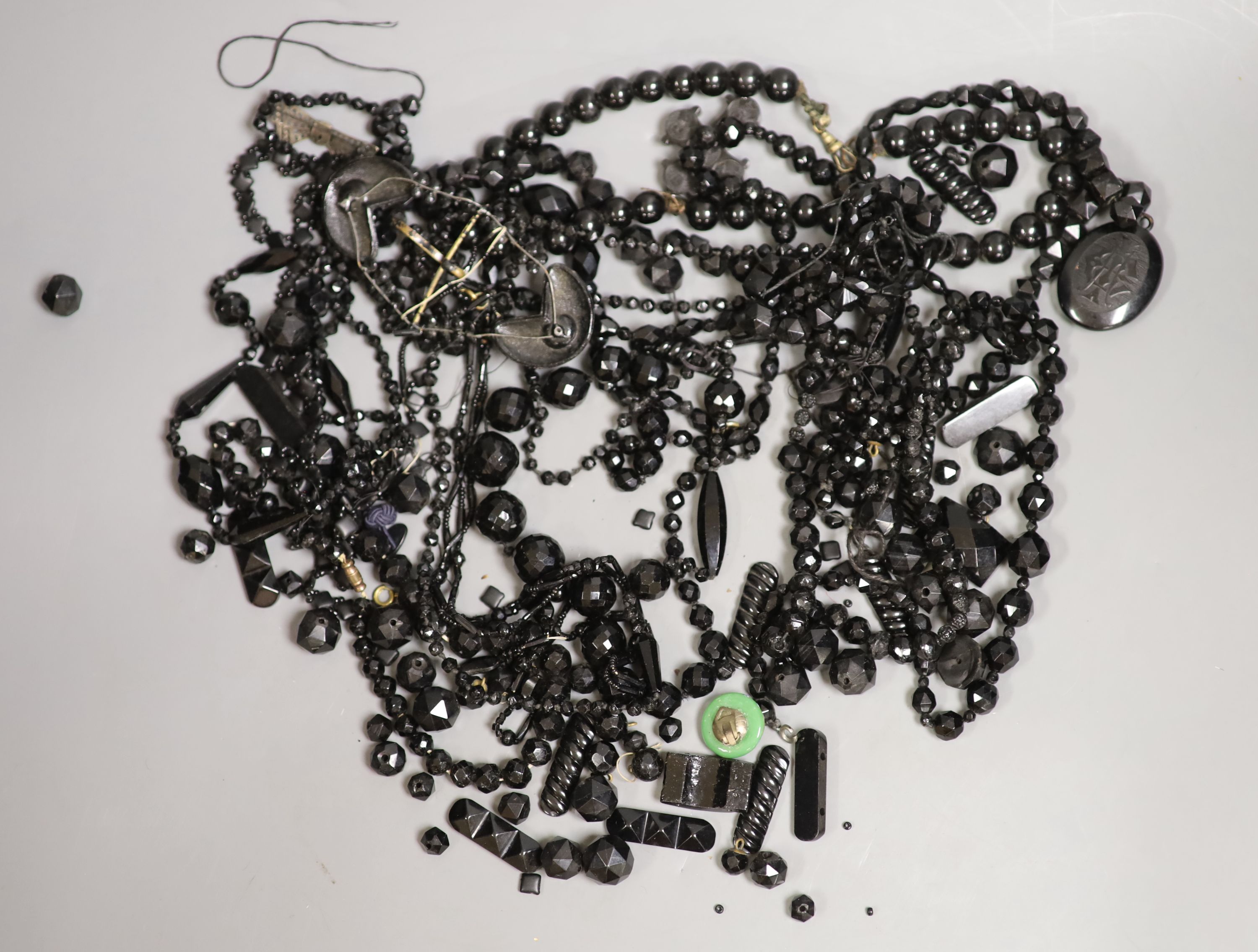 A quantity of assorted mainly jet jewellery including cross pendant necklaces and locket pendant necklace.